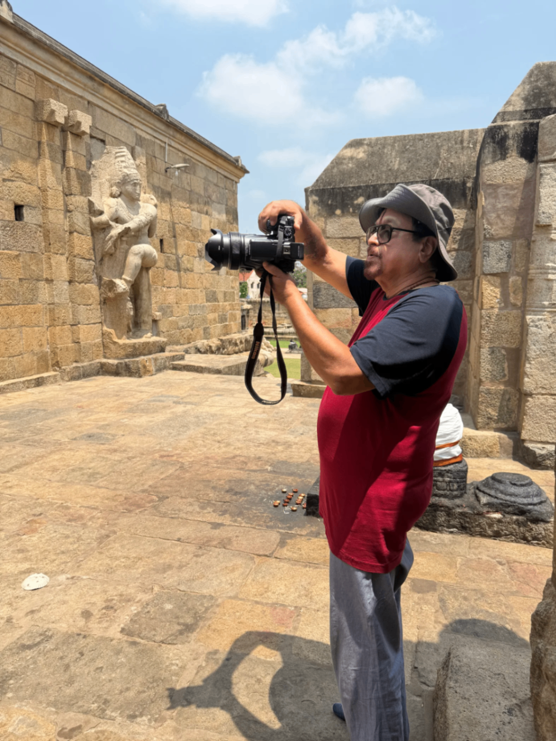 Photographer capturing ancient temple sculpture